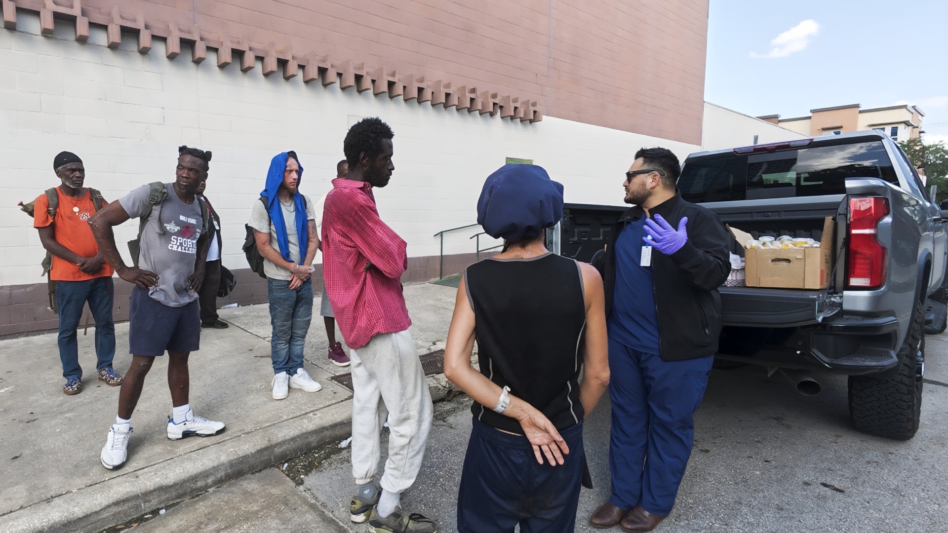 JC Lives speaking with neighbors beside the food distribution truck